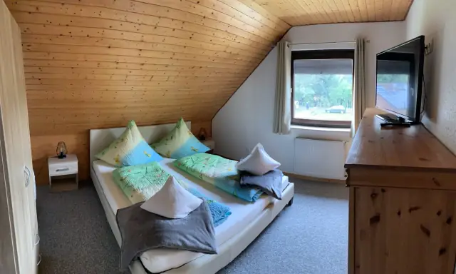 Erstes Schlafzimmer mit Doppelbett und Kommode